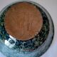 Bowl on a circular base or small blue ceramic dish.