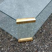 1970s designer coffee table in glass, plexiglass, and gold metal.