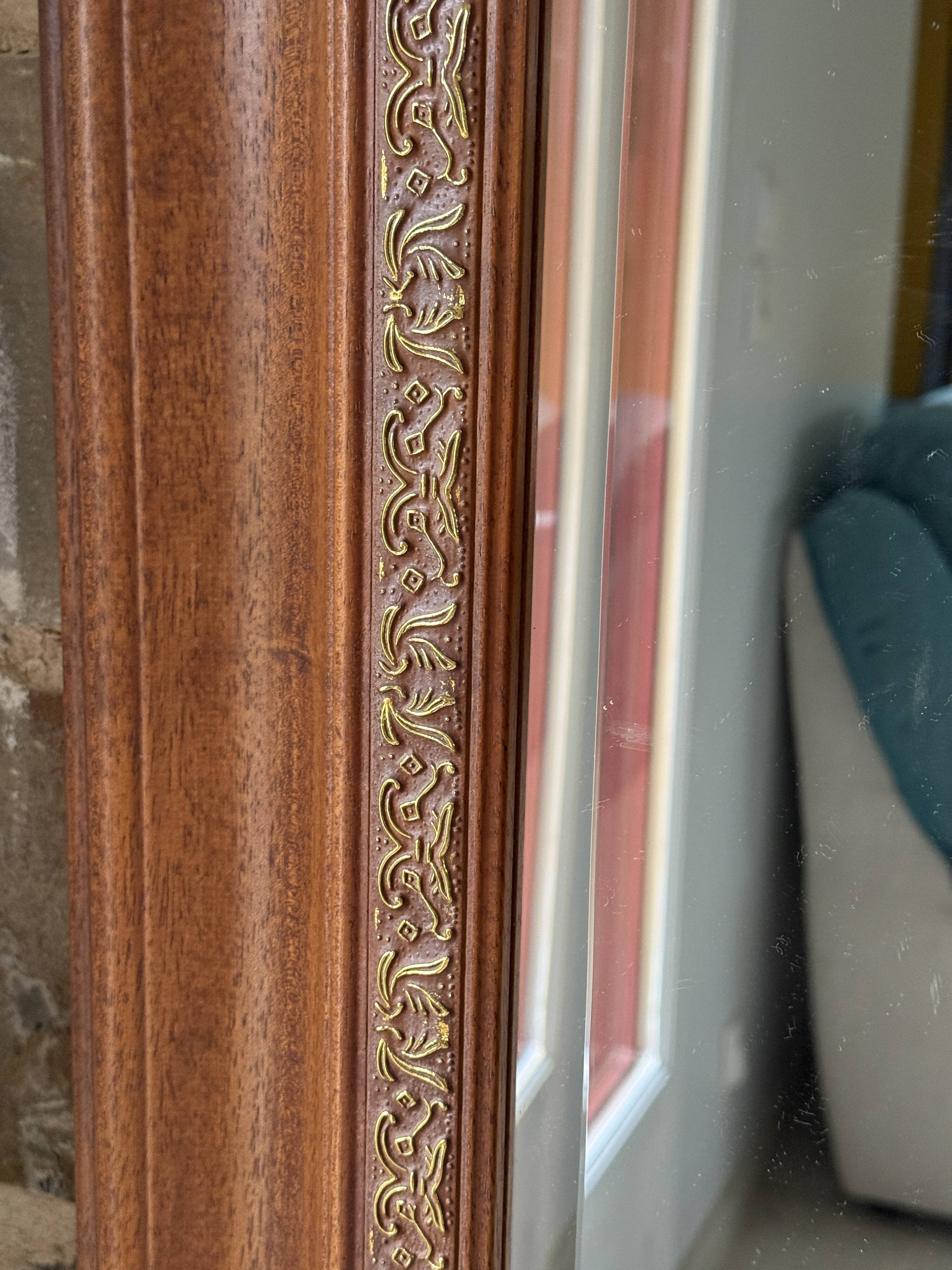 Large bevelled tabletop mirror in carved gilded wood.