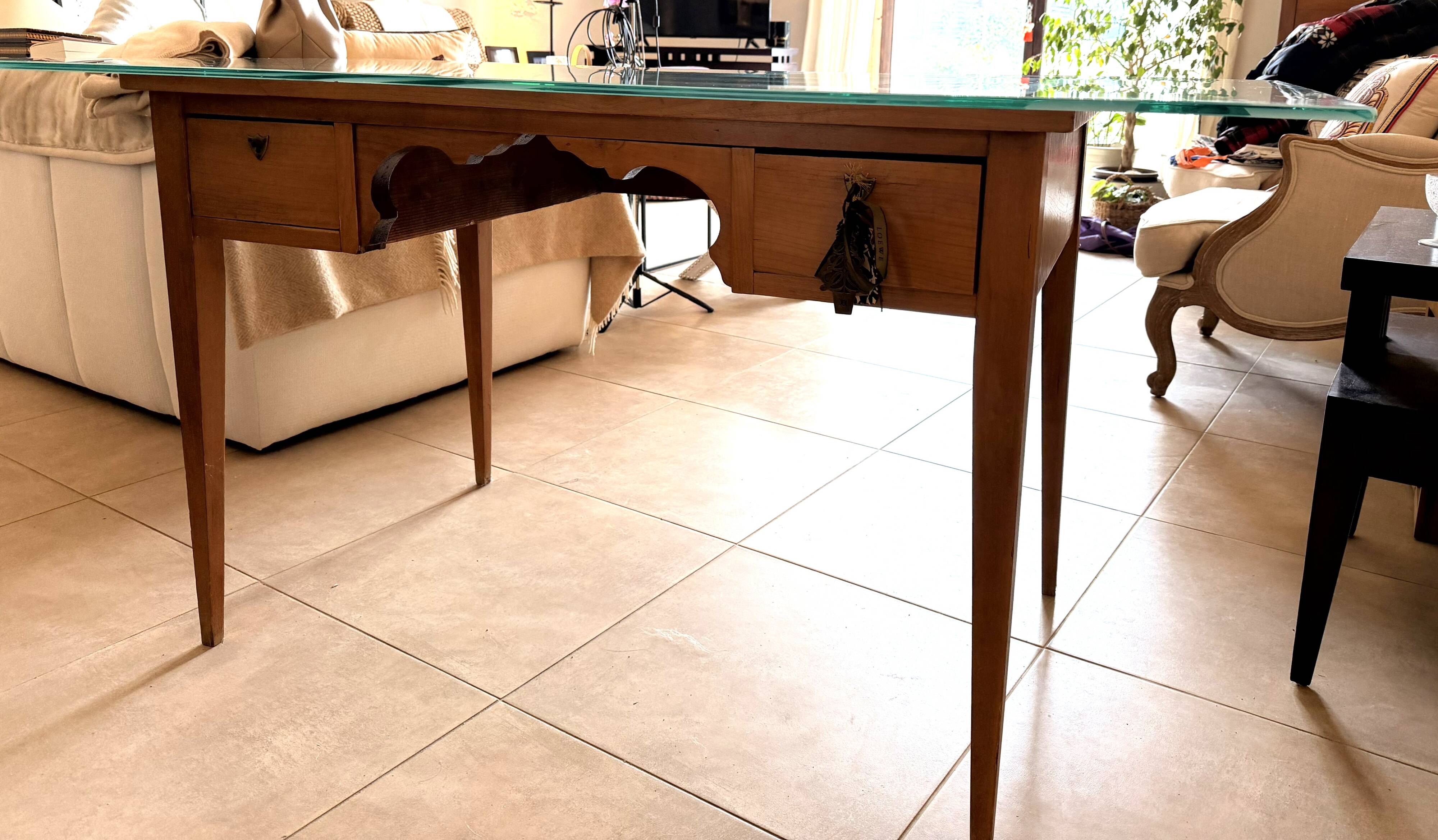 Elegant antique desk in cherry wood with a black leather top and glass plate.
