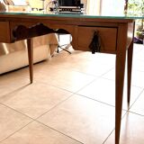 Elegant antique desk in cherry wood with a black leather top and glass plate.