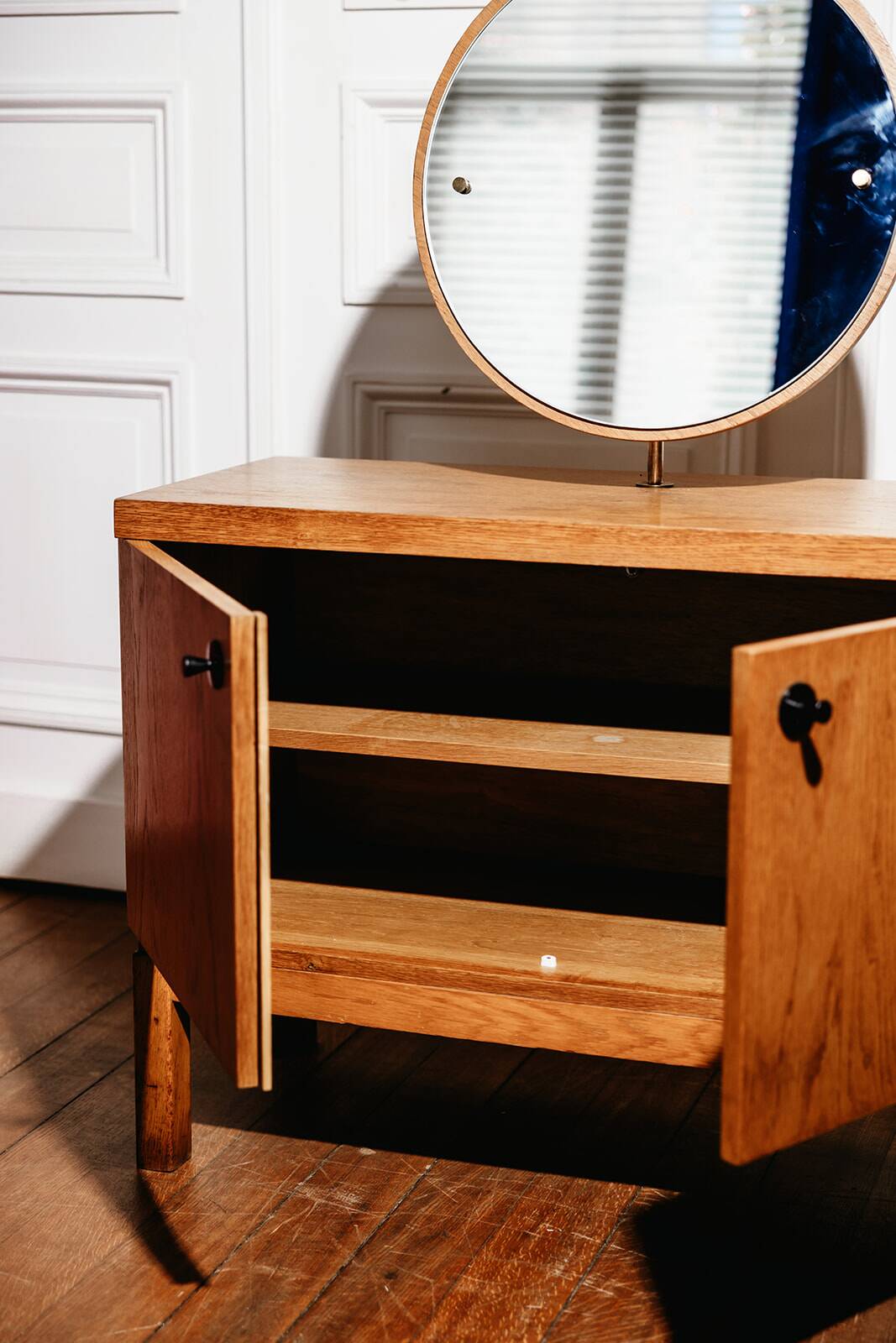 Vintage oak cabinet with circular mirror, 1960s modernist design.