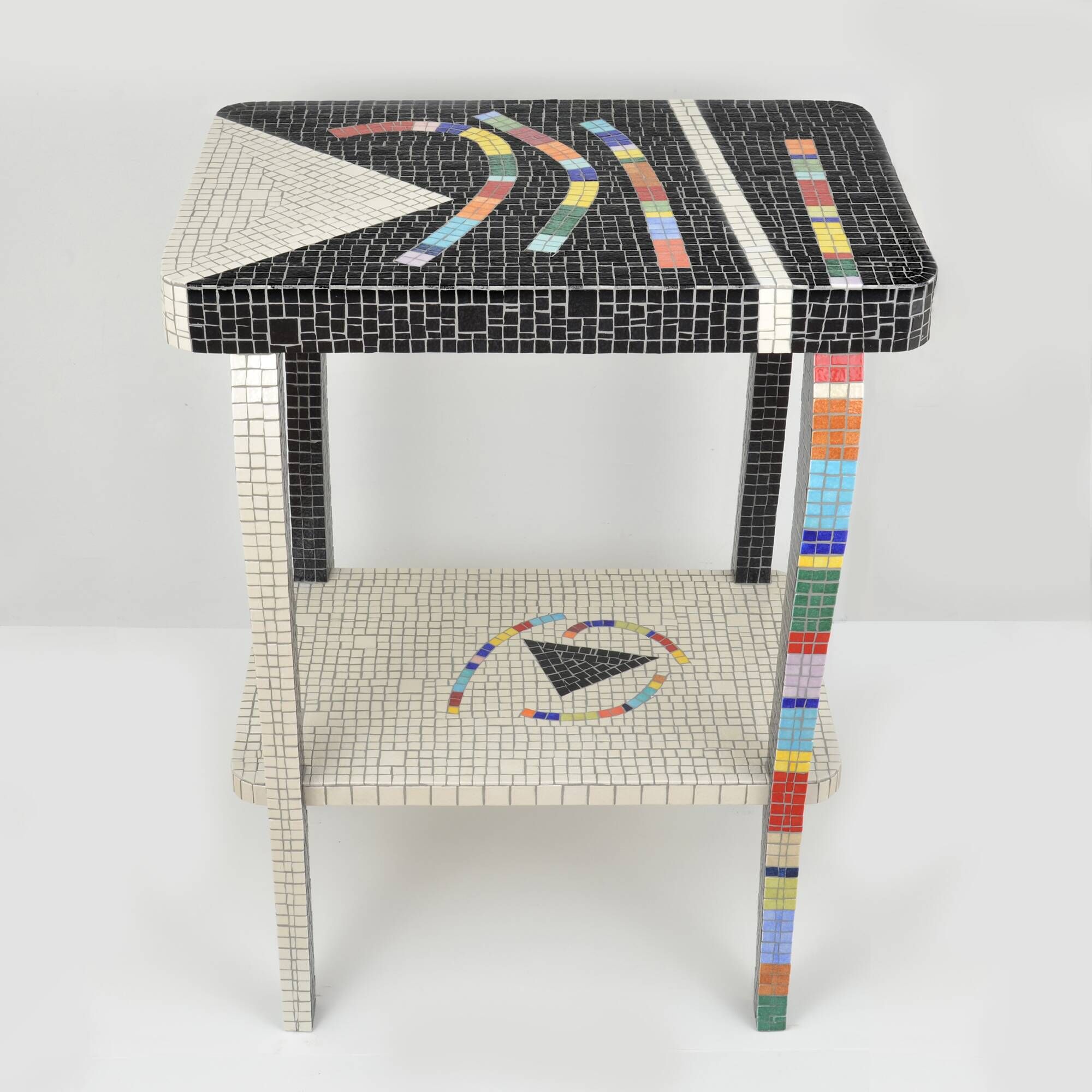 Table topped with a ceramic mosaic featuring an abstract design.