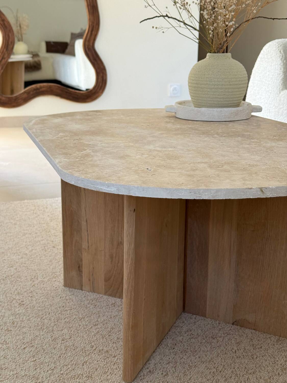 Oval coffee table in travertine and raw oak.