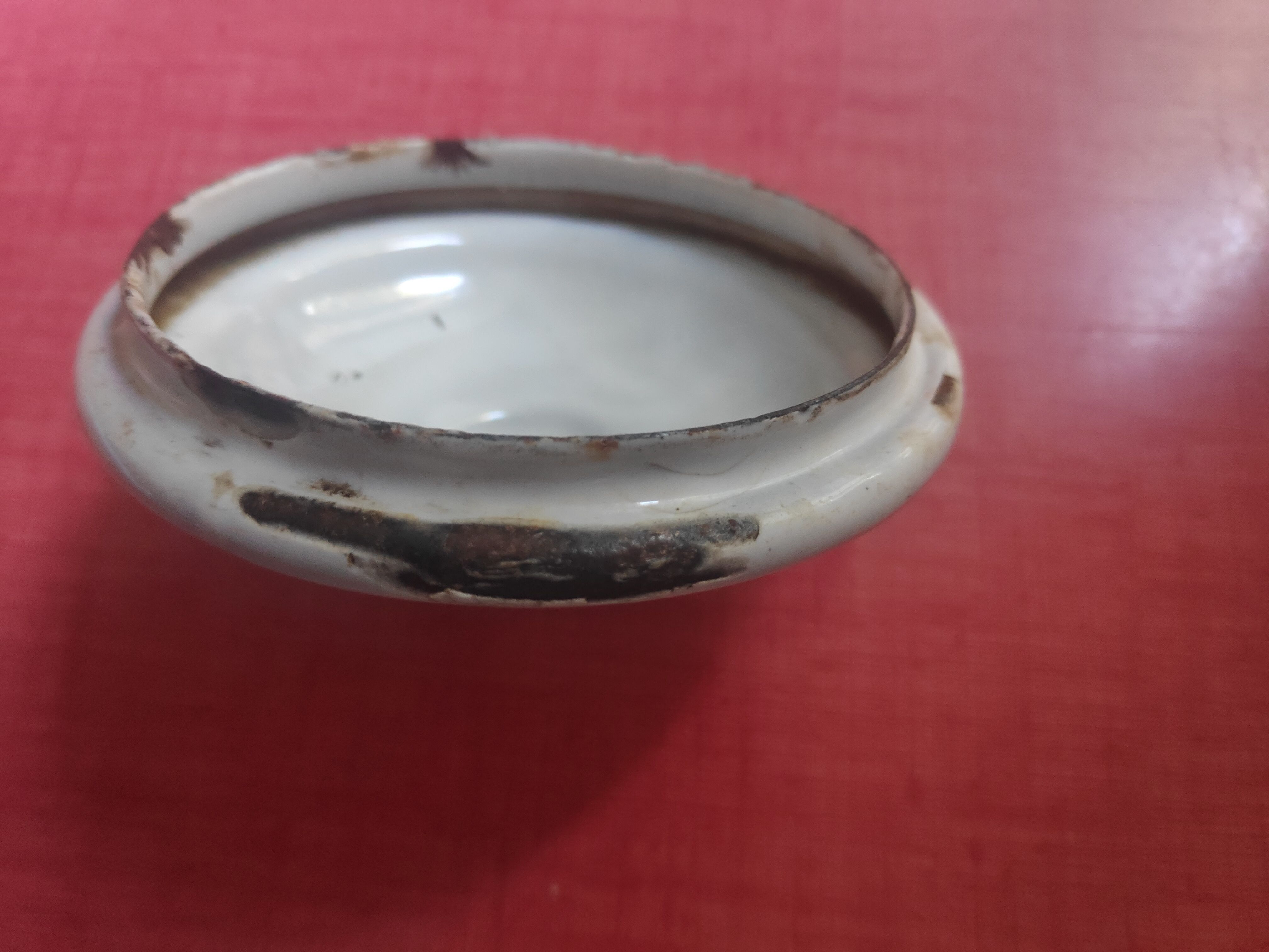 White enamelled sheet metal coffee maker with red and blue patterns