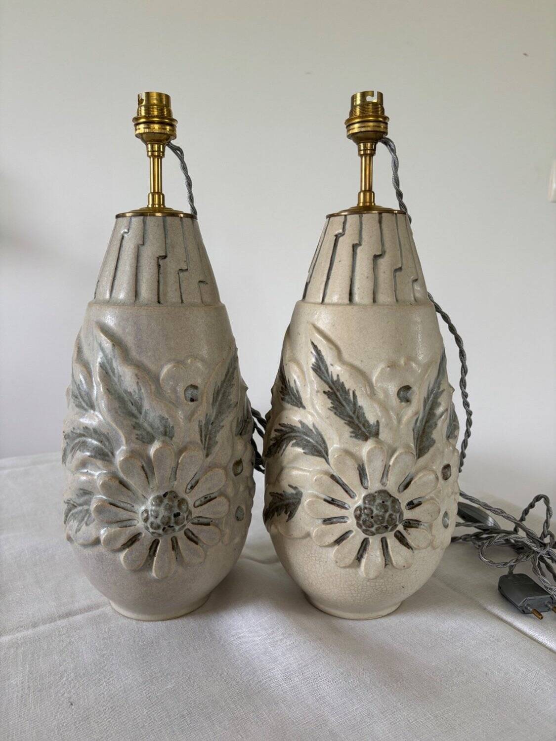Pair of white glazed stoneware lamp bases, 20th-century floral decoration.