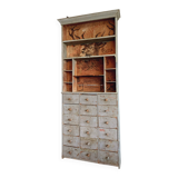 Craft cabinet with drawers with a very old tobacco advertisement in the background