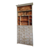 Craft cabinet with drawers with a very old tobacco advertisement in the background