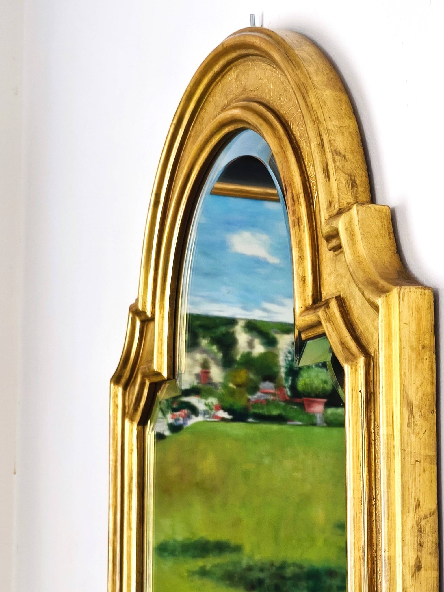Florentine arched mirror in gilded wood with gold leaf.