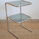 Glass-topped side table with tubular metal.