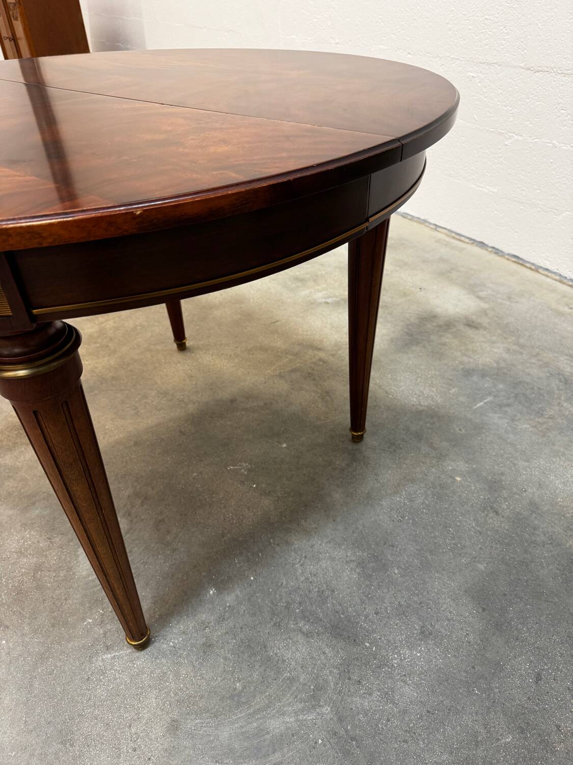 Extendable mahogany round table in Louis XVI style