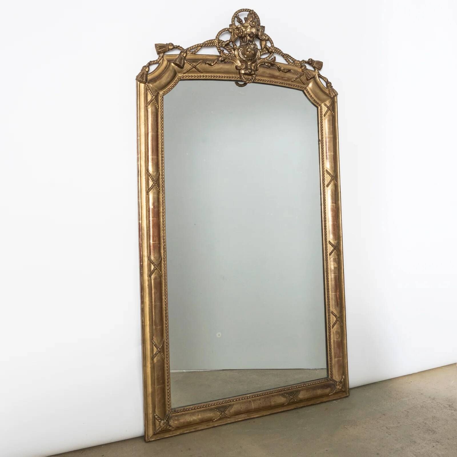 Miroir en bois doré de style néo-classique à motif corde et pompons