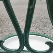 Bottle green enamelled cast iron umbrella stand with a swirl design.