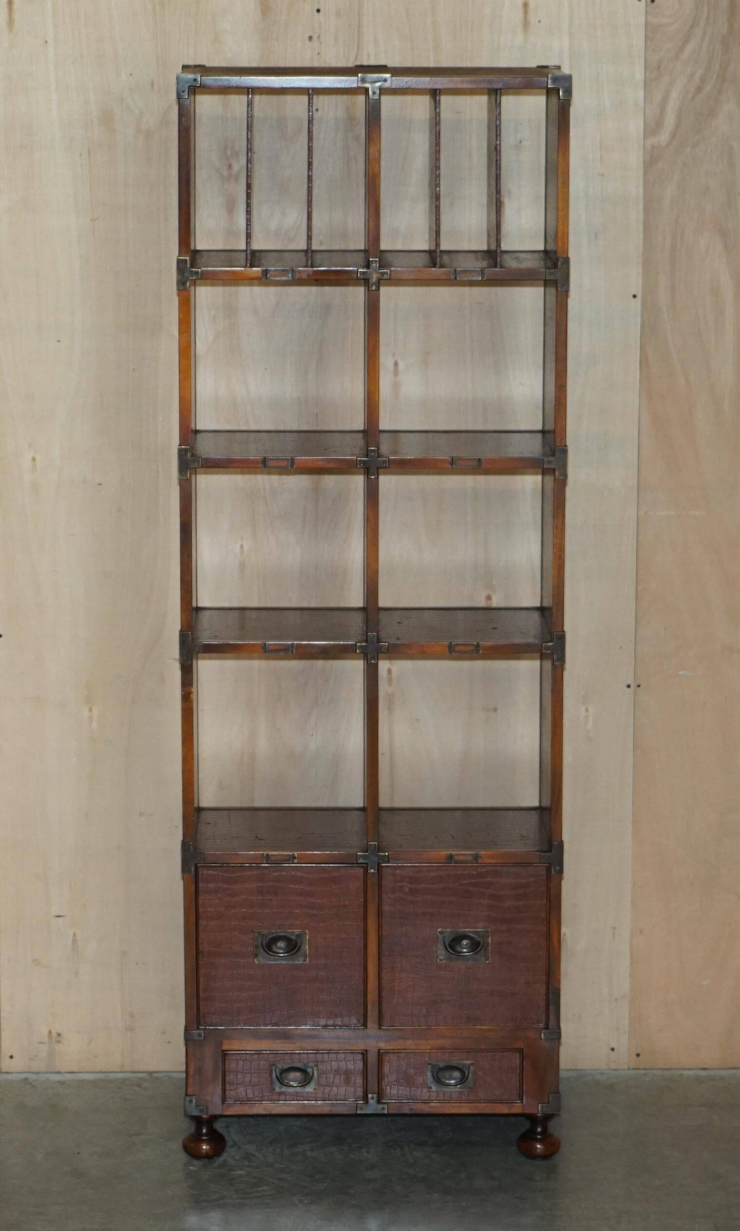 Pair of open bookshelves in crocodile leather with drawers and compartments.