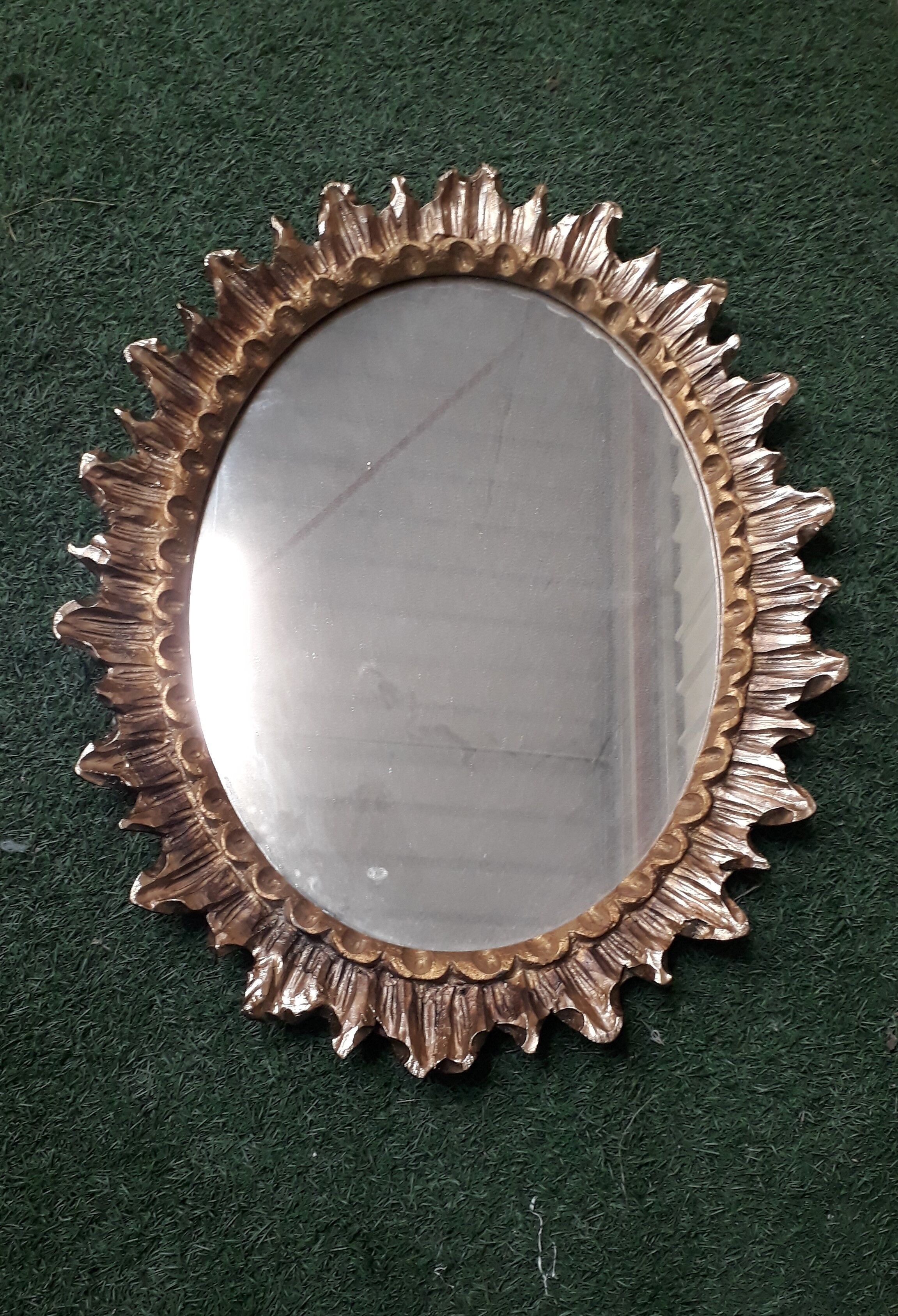 Oval sun mirror made of gilded solid wood