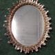 Oval sun mirror made of gilded solid wood