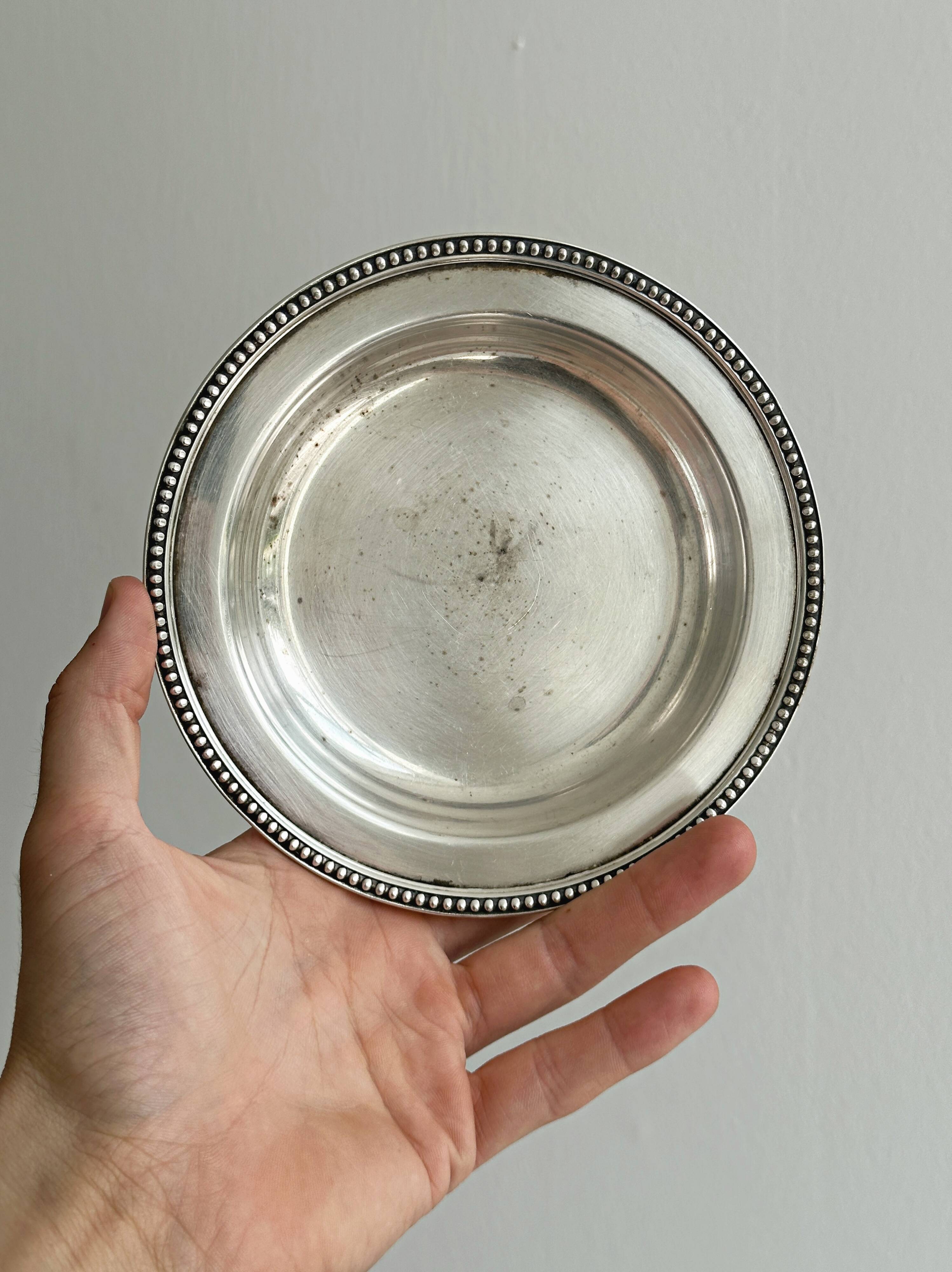 Round patinated silver-plated metal dish