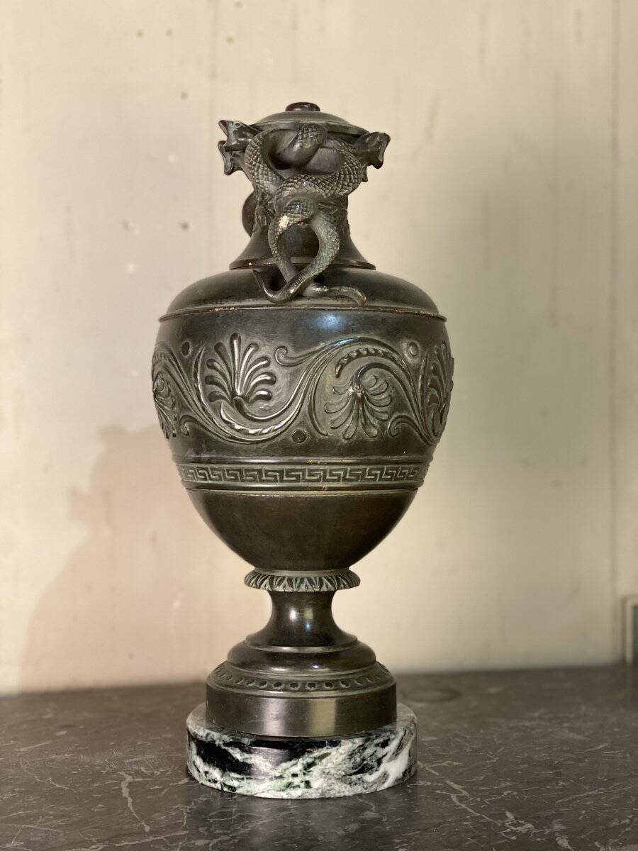 Bronze vase with snakes and a green patina, in the antique style.