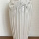 Old white art nouveau vase with flowers and dragonflies