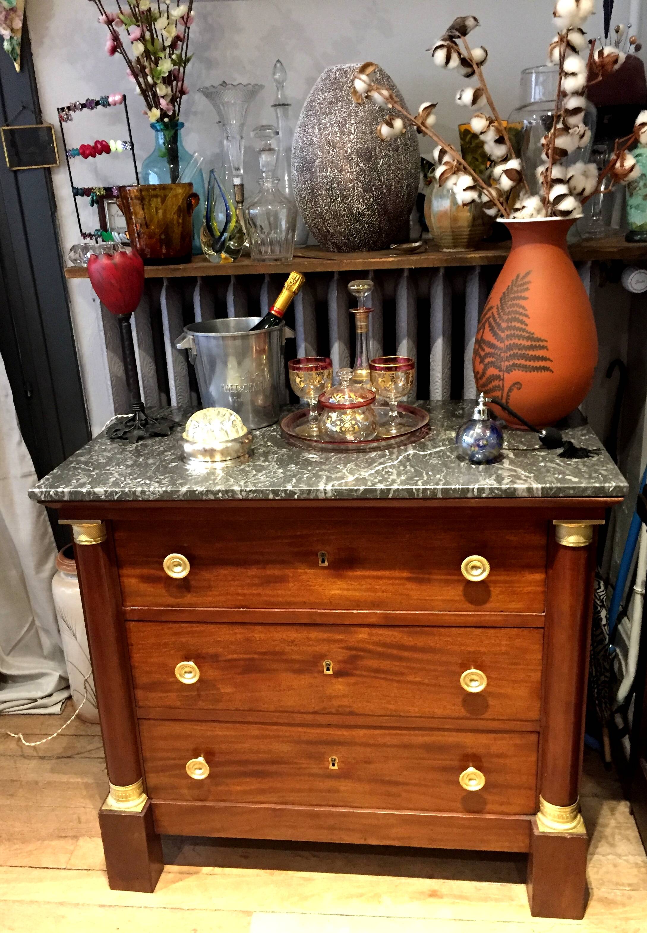 Empire chest of drawers with half columns in mahogany and gilded bronze
