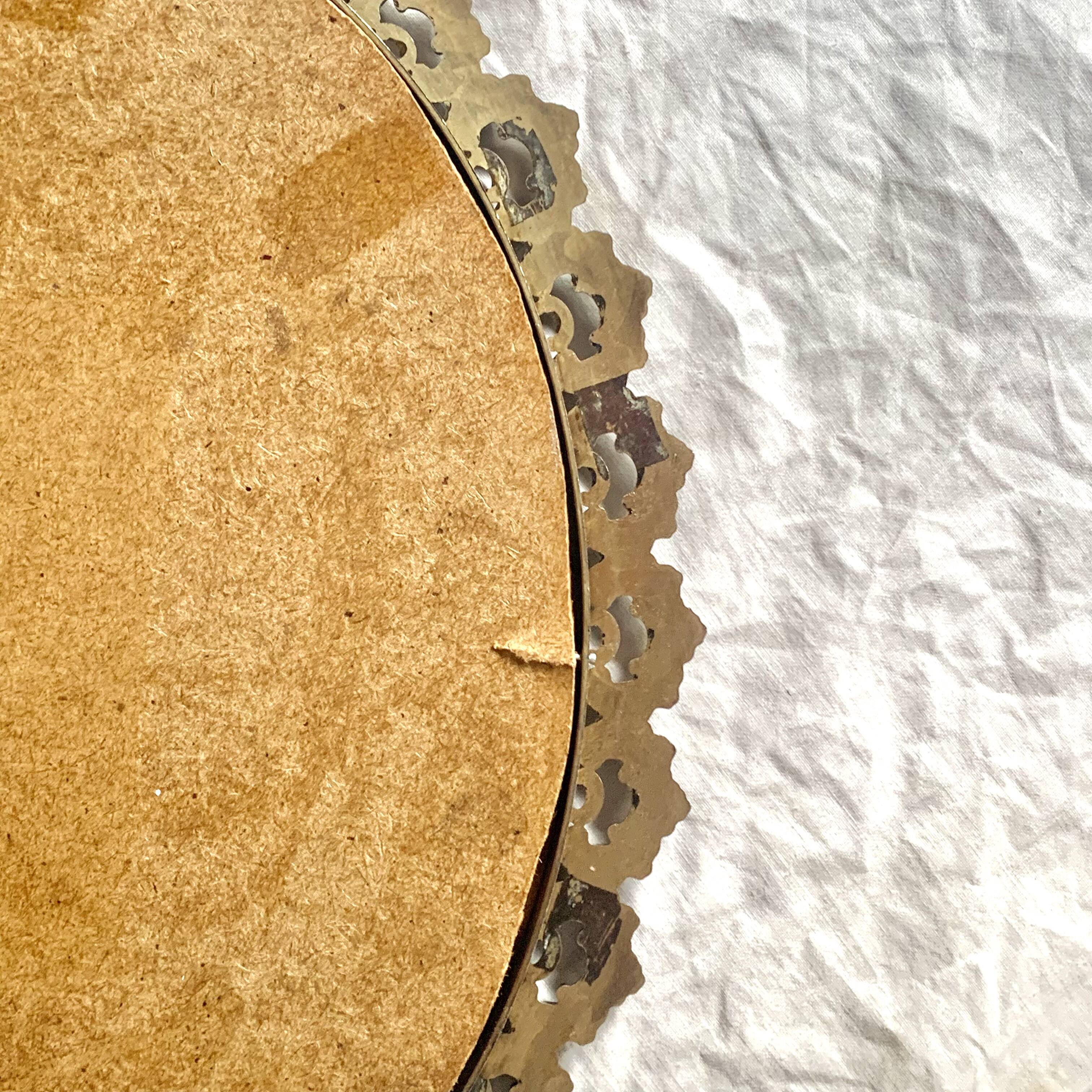 Old oval wall mirror in gilded brass