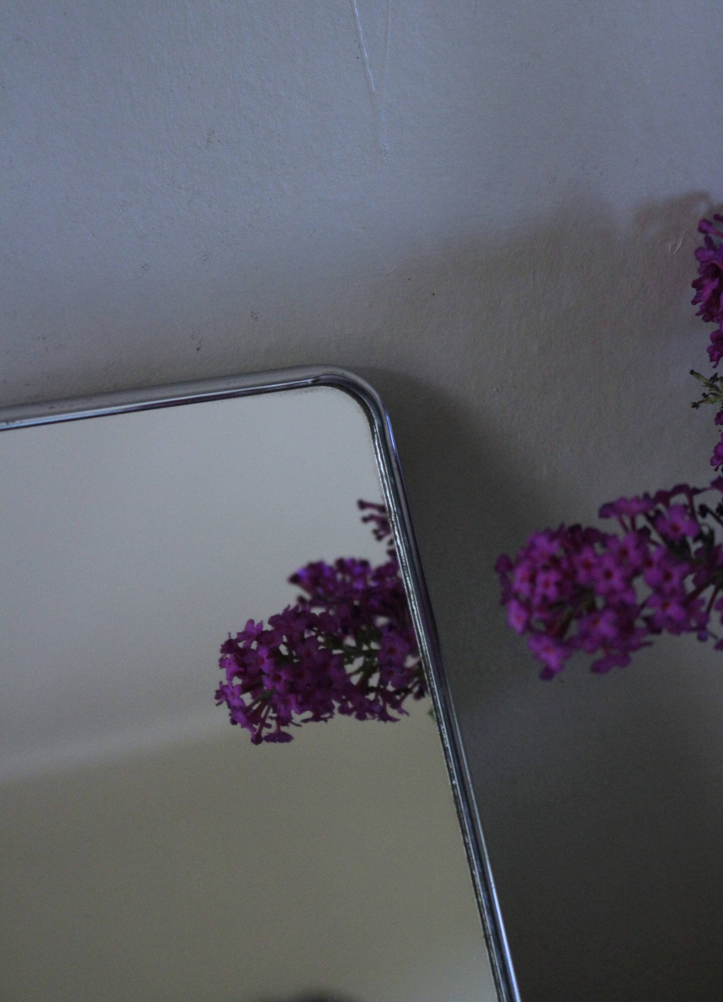 Simple rectangular barber mirror with a stand.
