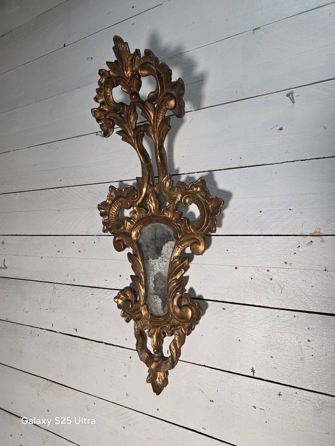 Italian mirror in gilded wood with gold leaf from the 18th century.
