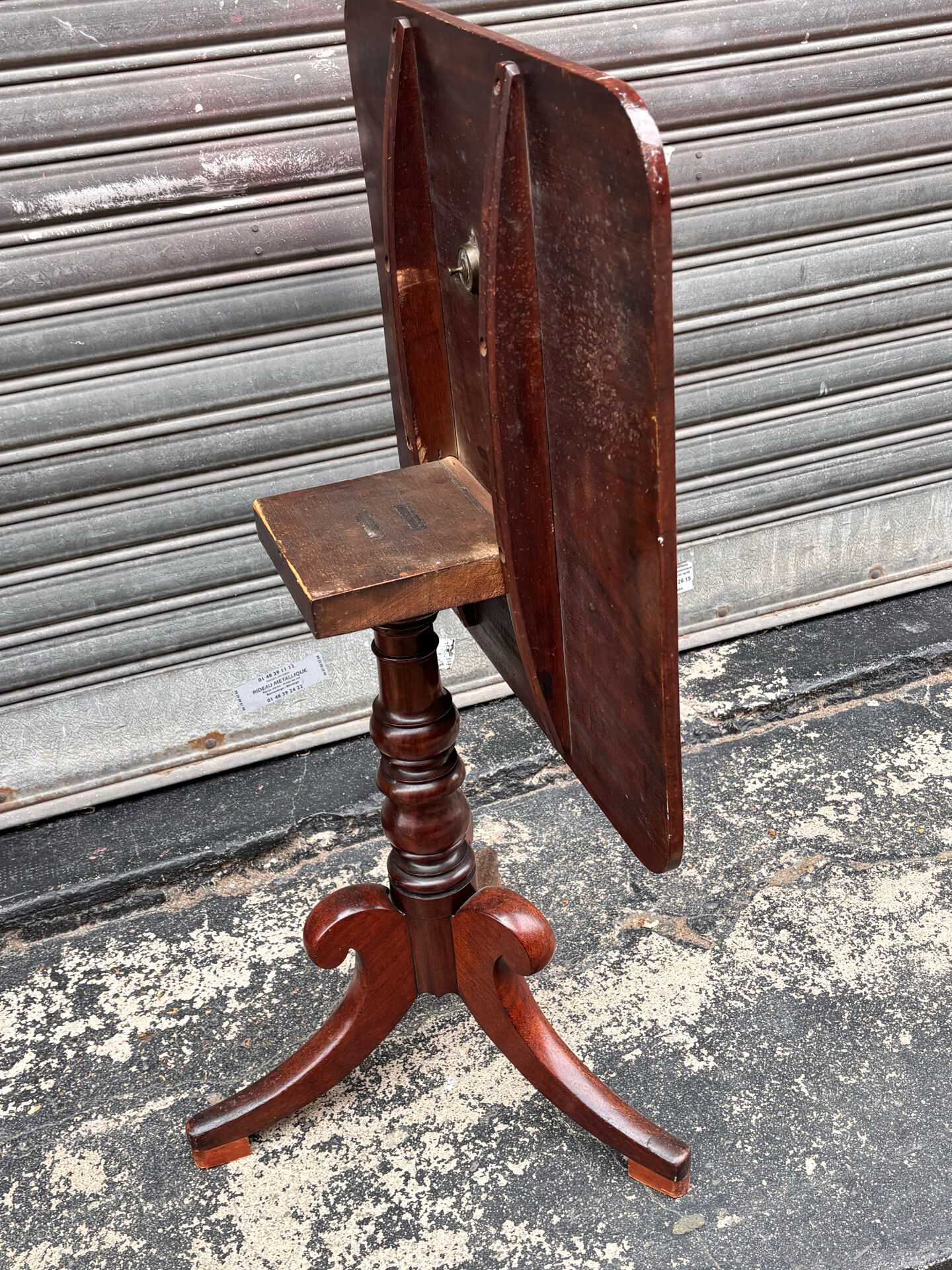 19th-century solid mahogany table with a tilting top and brass mechanism.