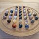 Wooden solitaire game with semi-precious stones