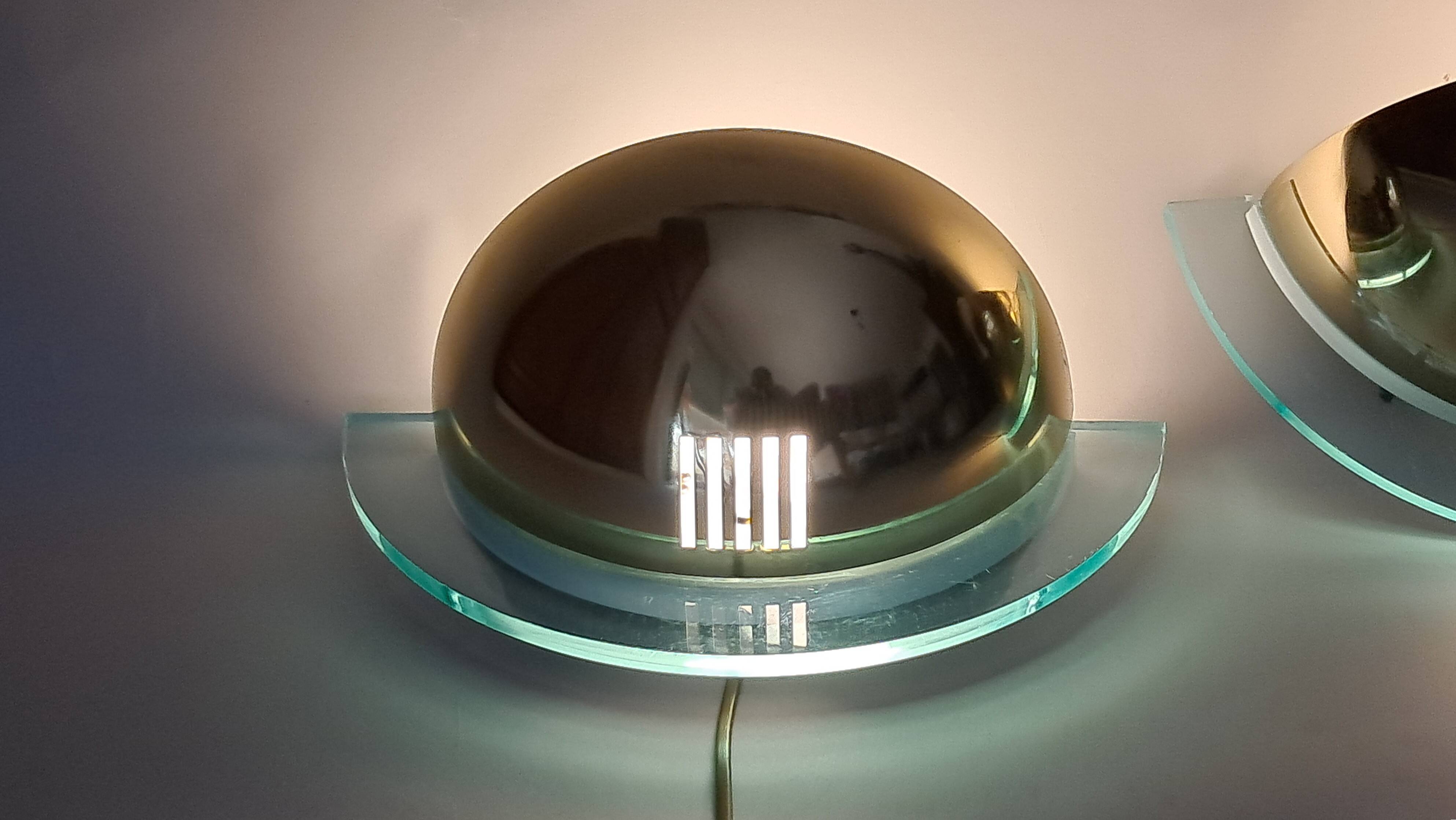 Pair of gold metal and plexiglass wall lights, circa 1980.