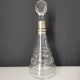 Crystal bottle with silver metal neck rim