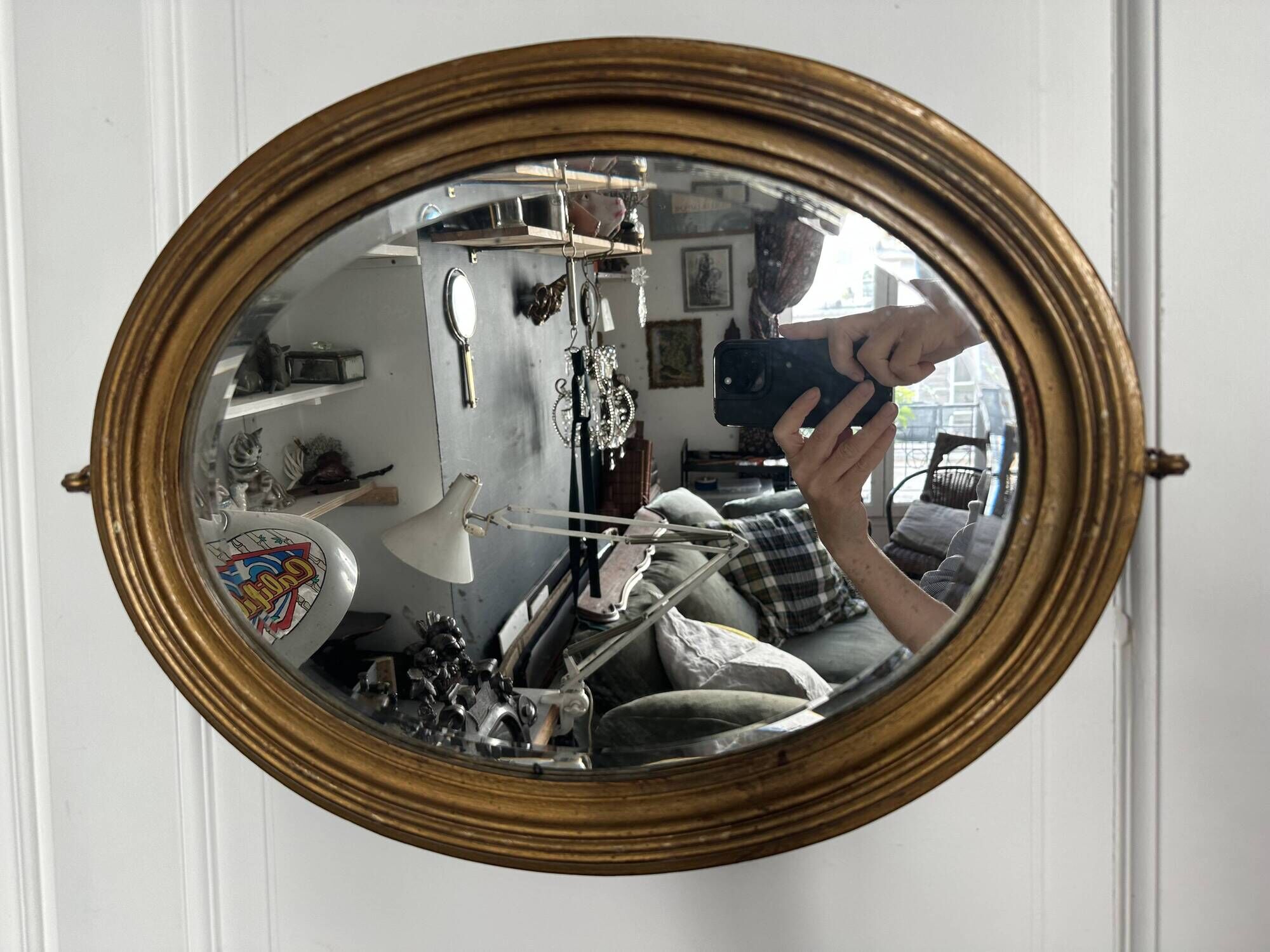 Antique oval mirror in gilded wood, bevelled mercury glass, 19th century.