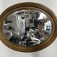 Antique oval mirror in gilded wood, bevelled mercury glass, 19th century.