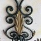 Pair of wall sconces in wrought iron with golden leaf patterns.
