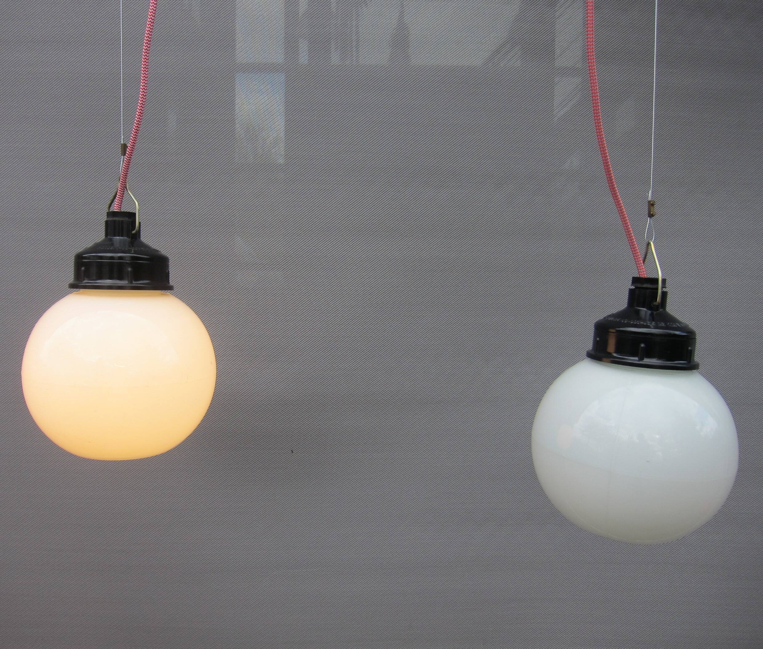 Trio of opal glass and bakelite globe pendant lights