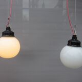Trio of opal glass and bakelite globe pendant lights