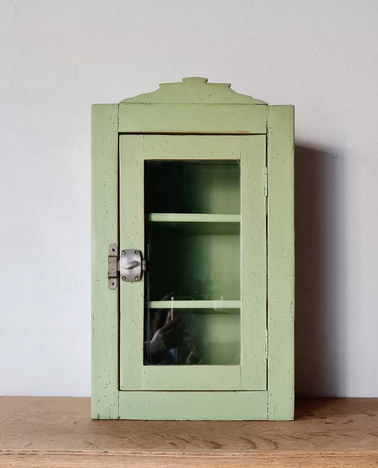 Small glass cabinet in green colour.