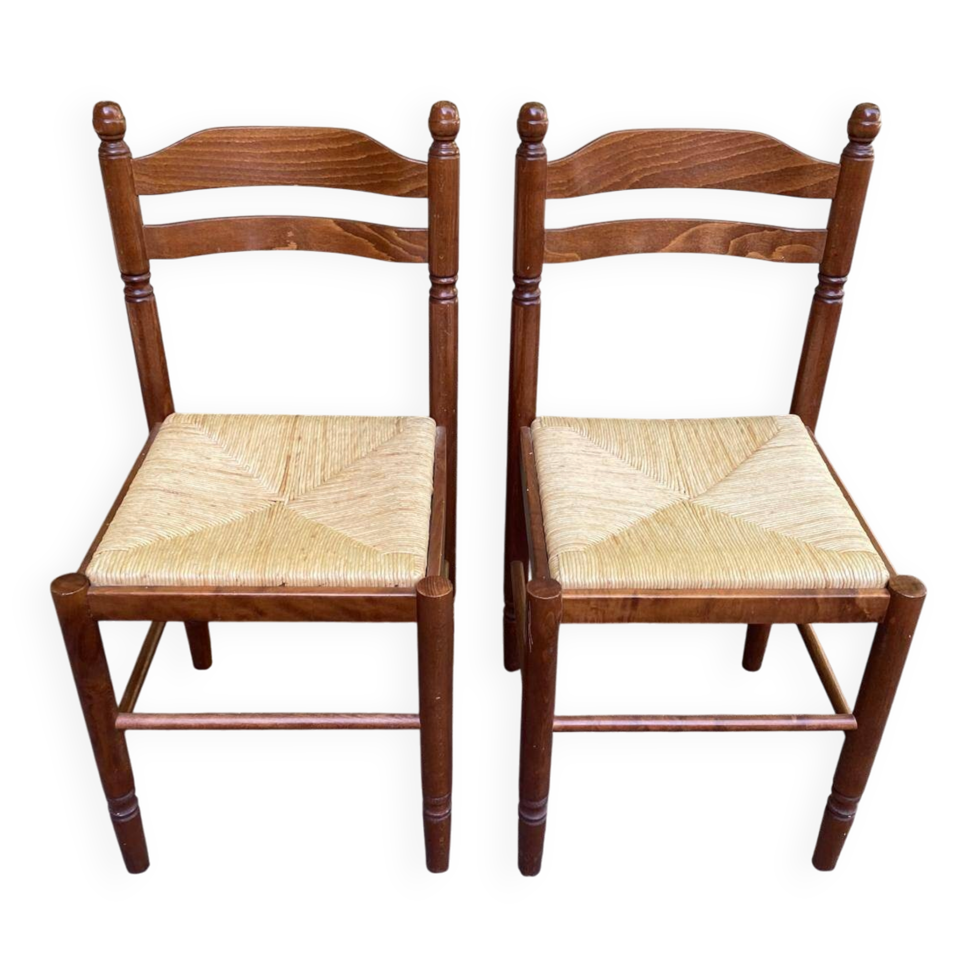 2 square wooden kitchen chairs with straw seats.