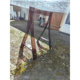 Vintage table with a glass top and smoked plastic trestle legs.