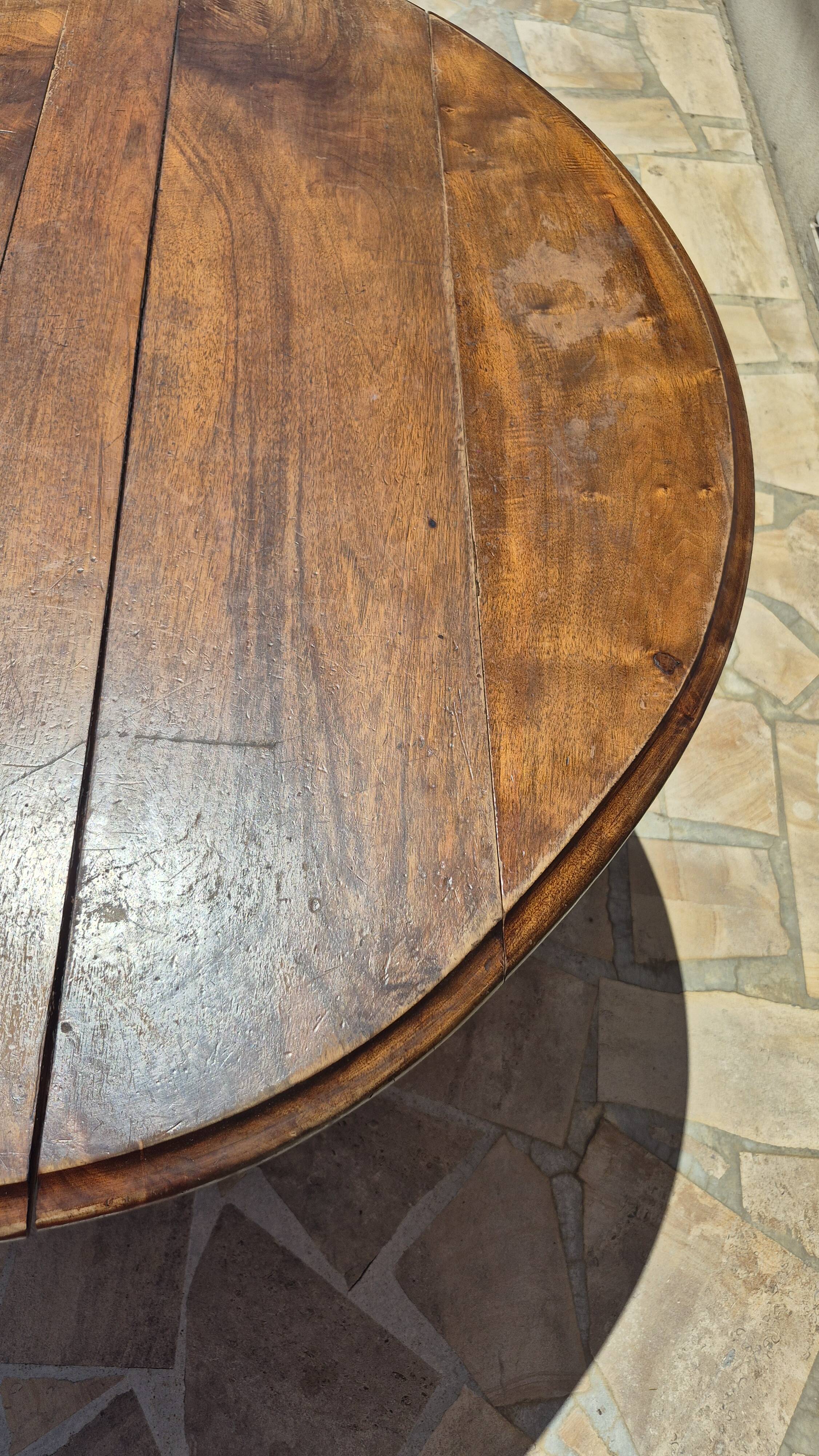 Round dining table with a drop-leaf top in solid walnut, late 19th century.