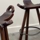 Set of 3 rustic carved oak bar stools with iron footrests, 1970s