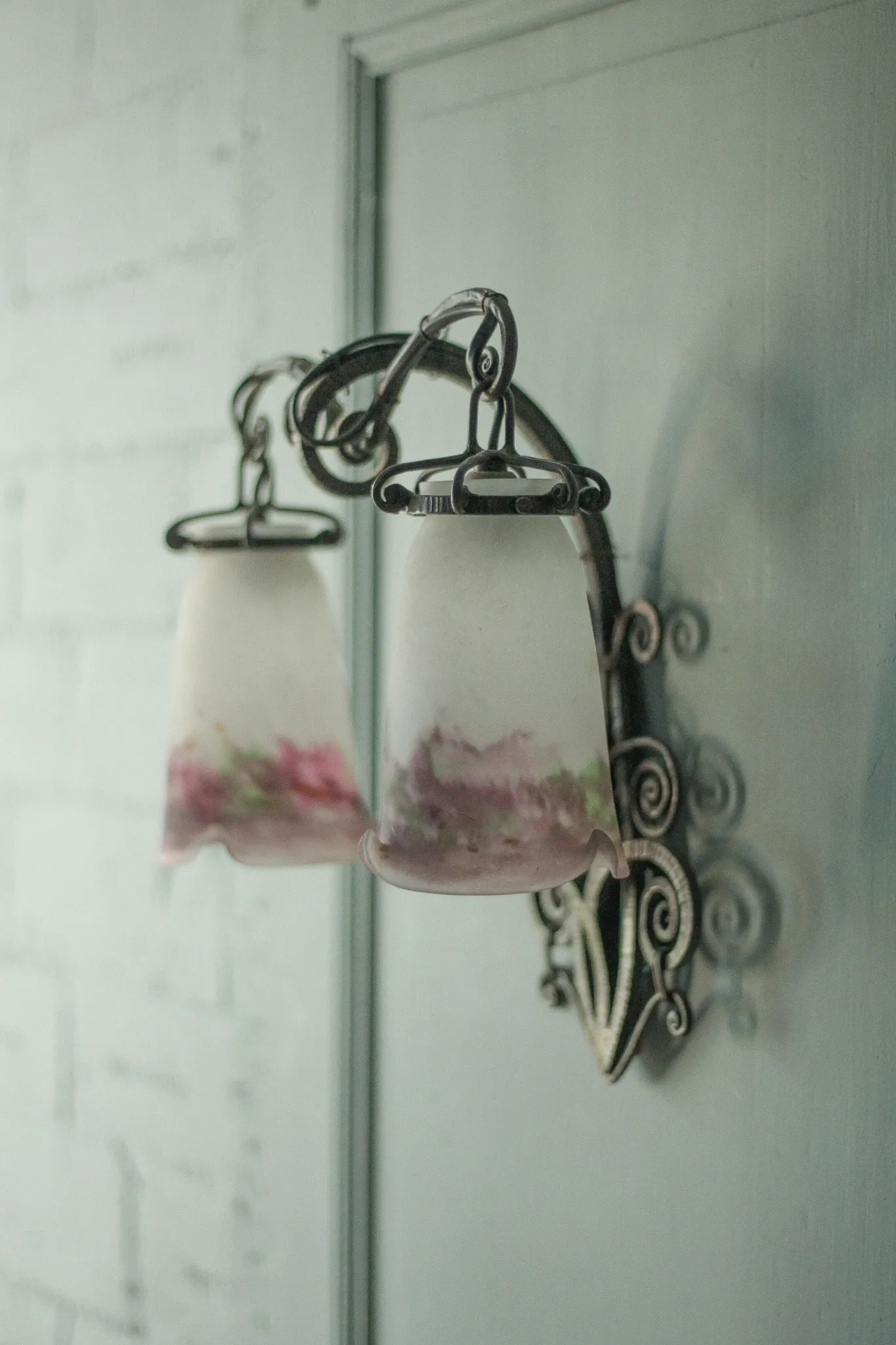 Wall lamp in wrought iron with a pink tulip glass globe by Muller glassworks.
