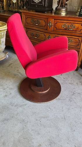 Old cinema chair with a red reclining seat.