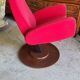 Old cinema chair with a red reclining seat.