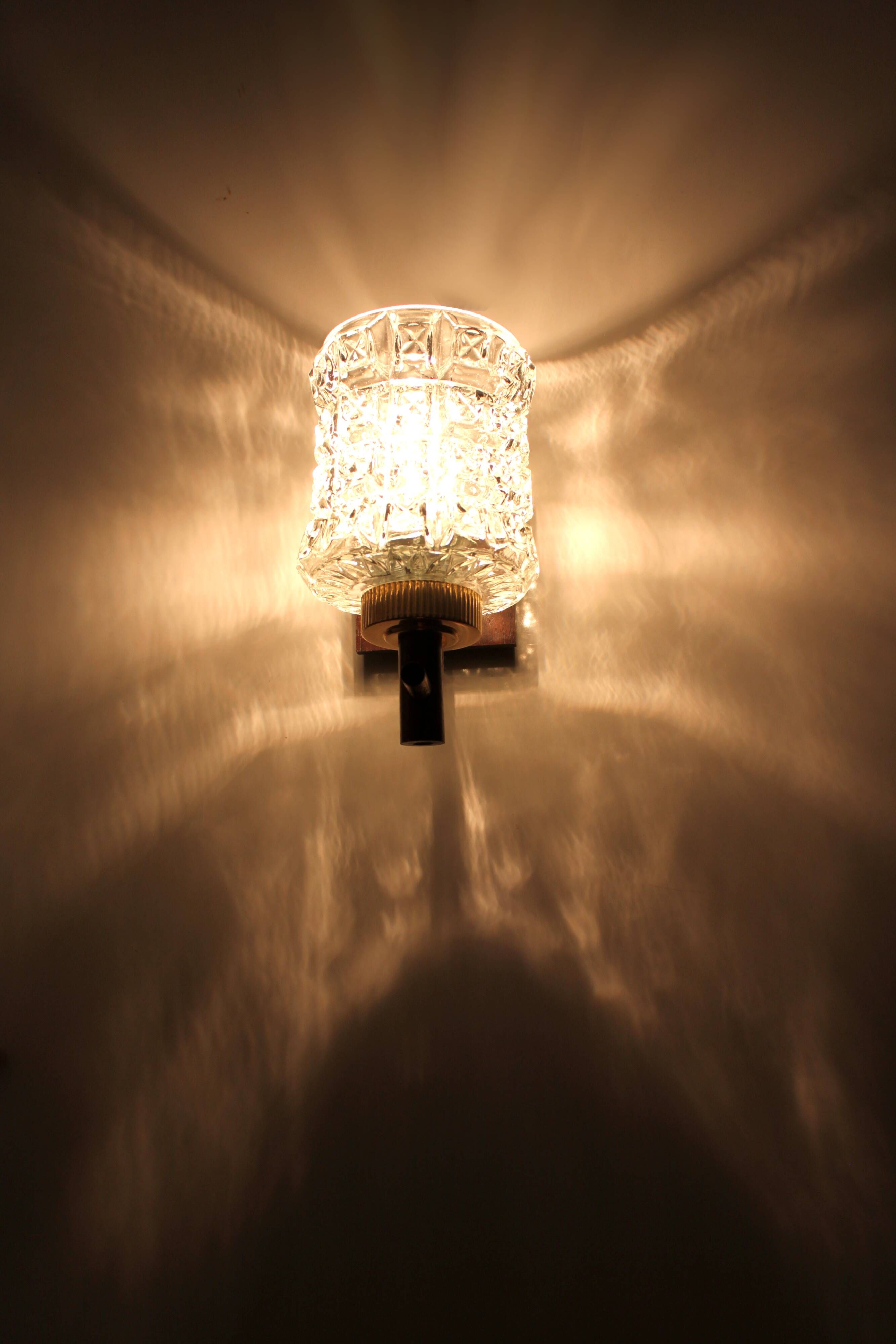 Pair of wall sconces in textured glass, wood, and gold metal, 1970.