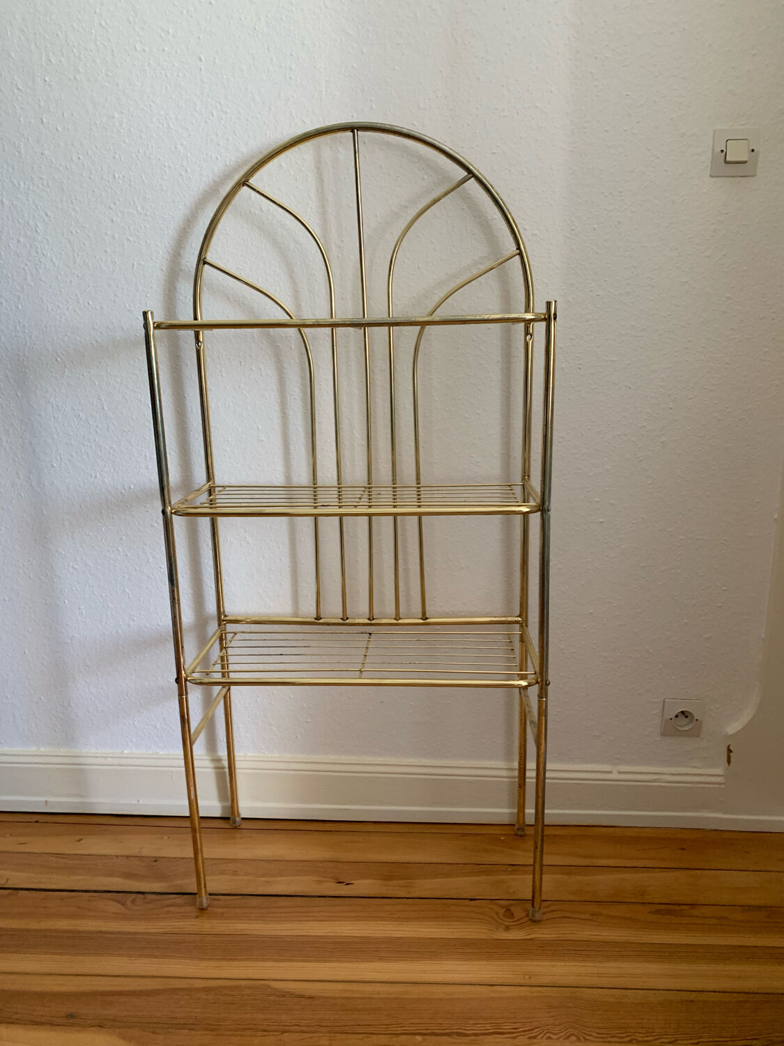 Gilded metal grid shelf in the shape of a vaulted arch