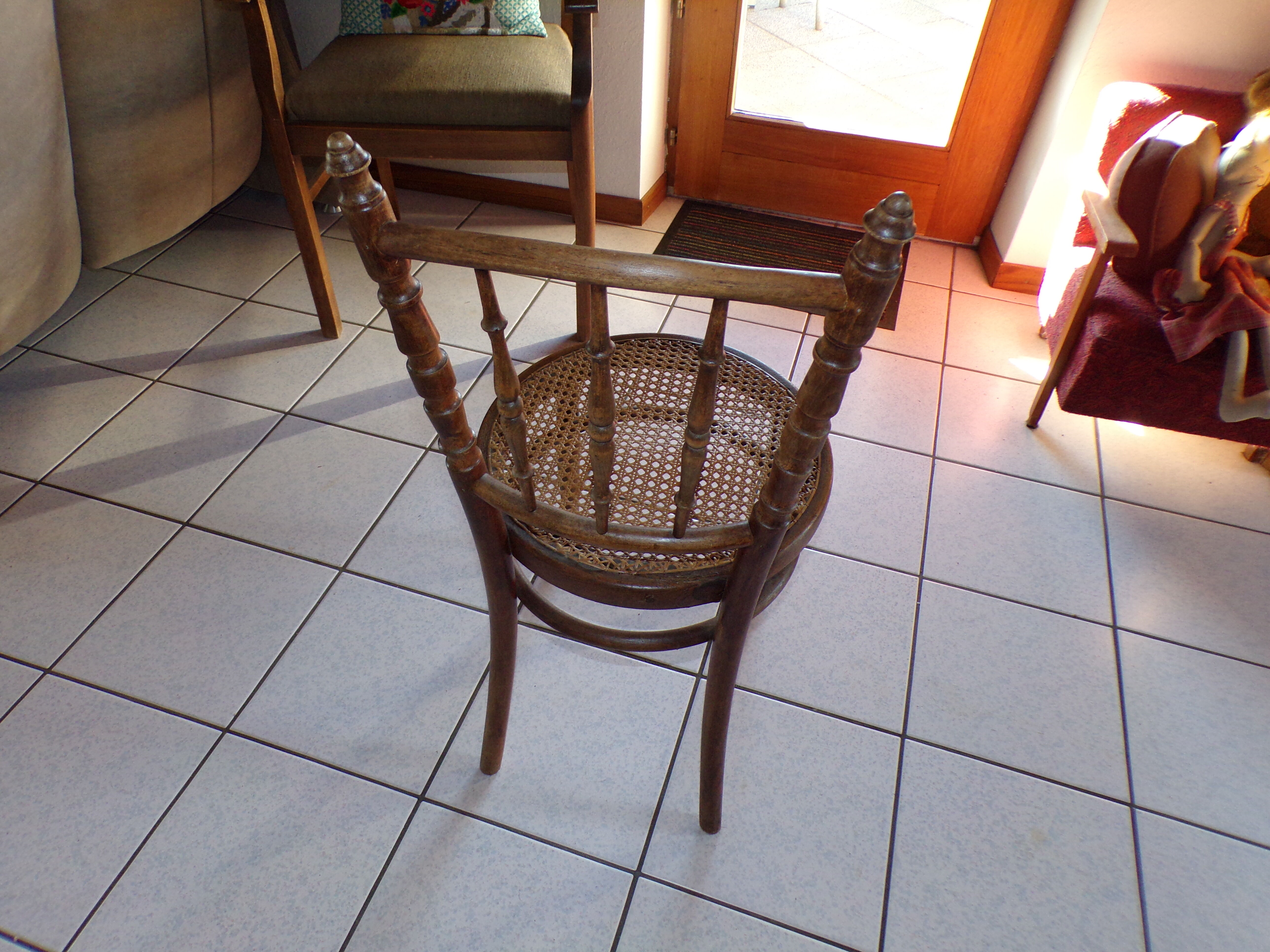 Curved wooden chair, turned and seated in cannage