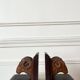 Pair of carved wooden bookends in the shape of ram's heads.