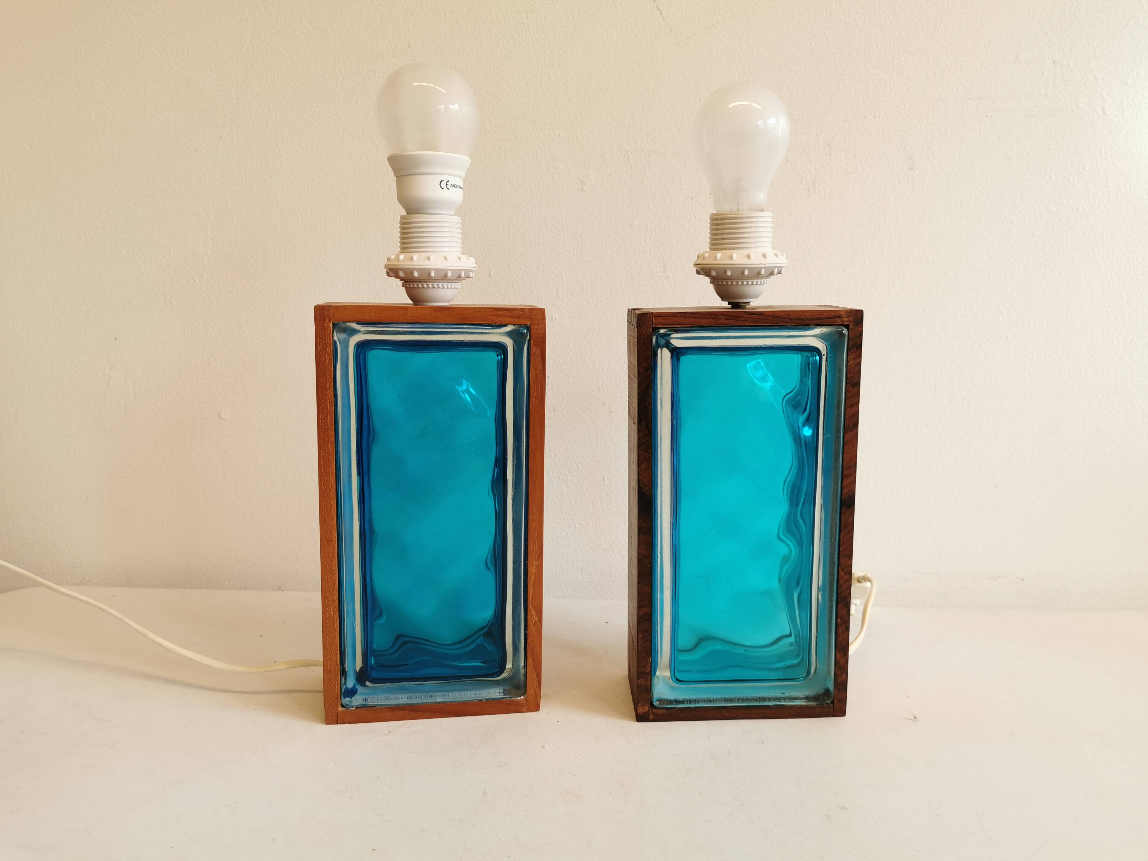 Two Swedish table lamps in solid pressed blue glass and teak wood "frame".