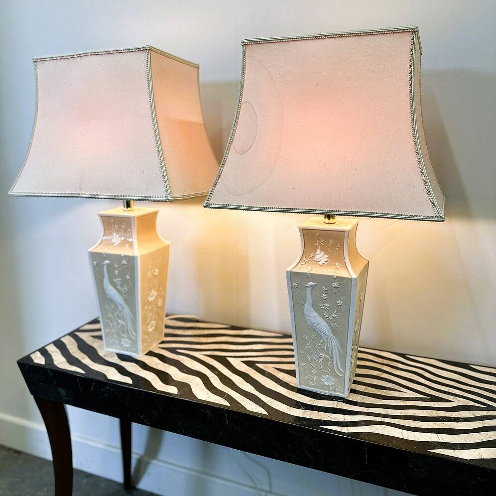 Pair of large cream ceramic table lamps with relief peacocks and fabric shades